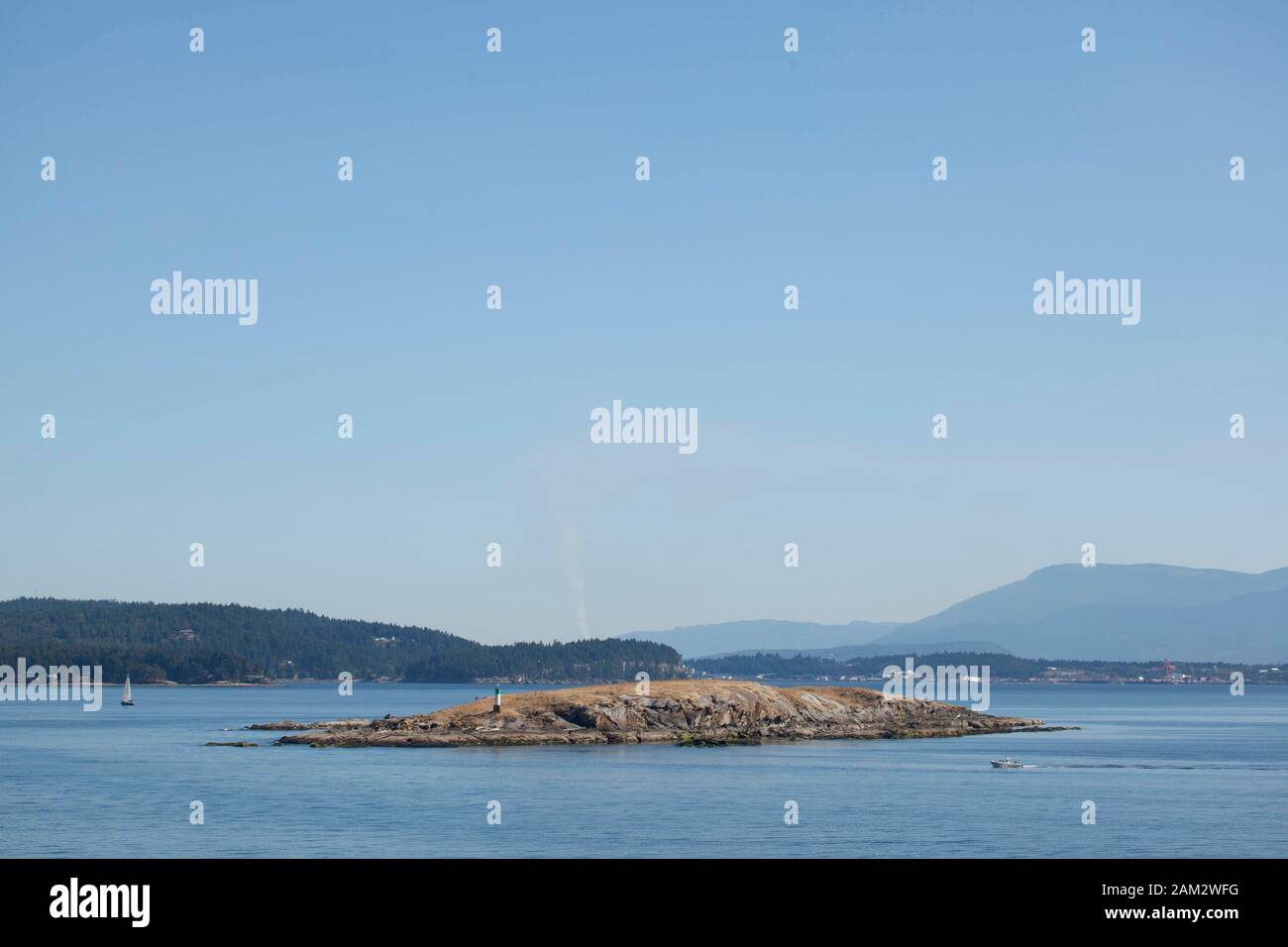 Seamark auf felsigen Inseln, Segelbooten und Bergkette im Hintergrund, Vancouver Island, British Columbia, Kanada Stockfoto