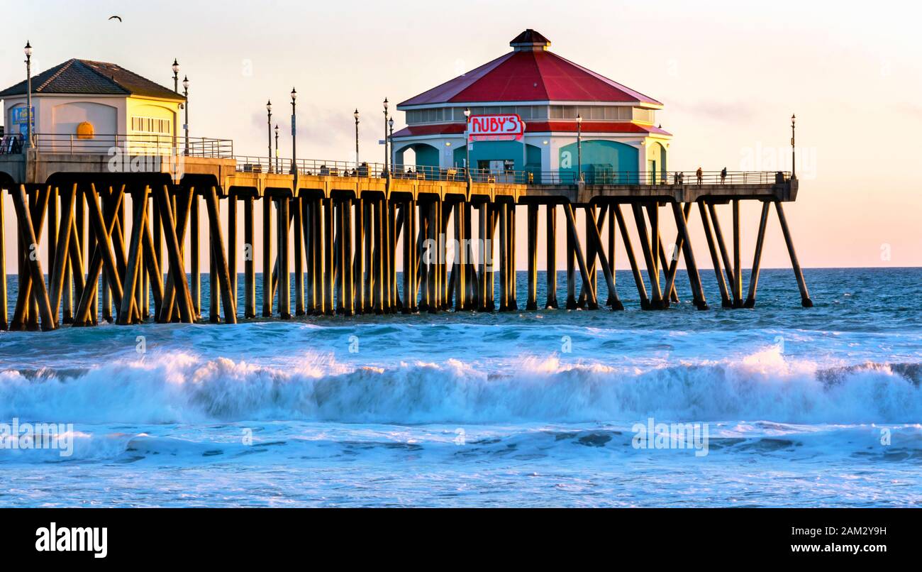 Berühmter Huntington Beach Pier bei Sonnenuntergang. Huntington Beach ist ein weltweites Touristenziel und bekannt als Surf City USA. Stockfoto