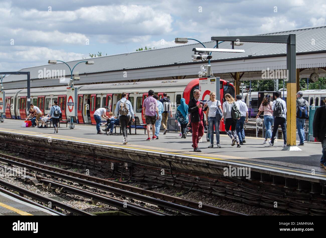 London, Großbritannien - 22. Juni 2019: Passagiere, die an einem sonnigen Sommertag auf einen District Line Zug am Ealing Broadway Station in West London warten. Stockfoto