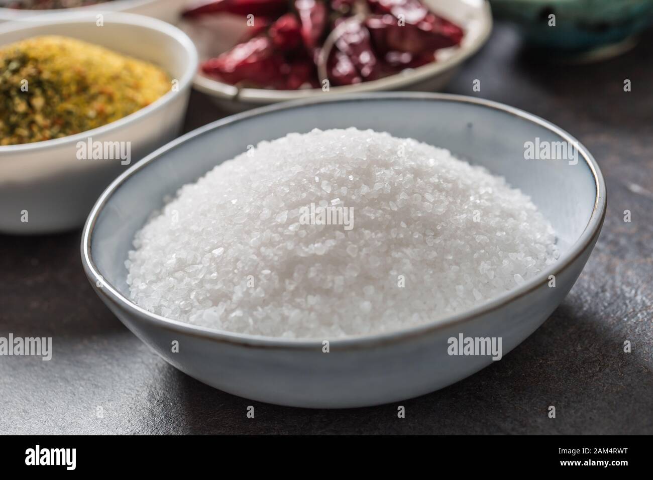 Salz und verschiedene Gewürze und Kräuter in Schüsseln Stockfoto