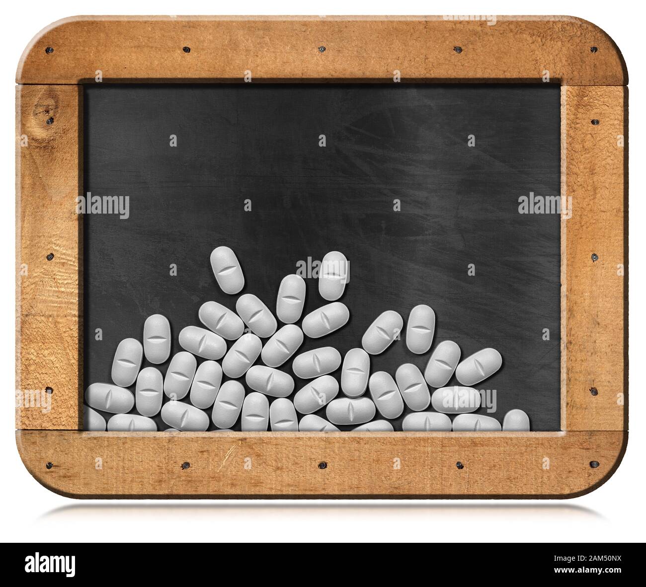 Nahaufnahme einer Gruppe weißer Pillen auf einer Tafel mit Holzrahmen und Kopierraum, isoliert auf weißem Hintergrund Stockfoto