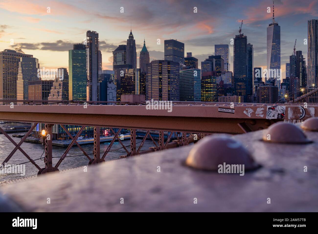 Skyline von New York aus Brooklyn Bridge bei Sonnenuntergang mit Wolken im Himmel im Hintergrund Stockfoto