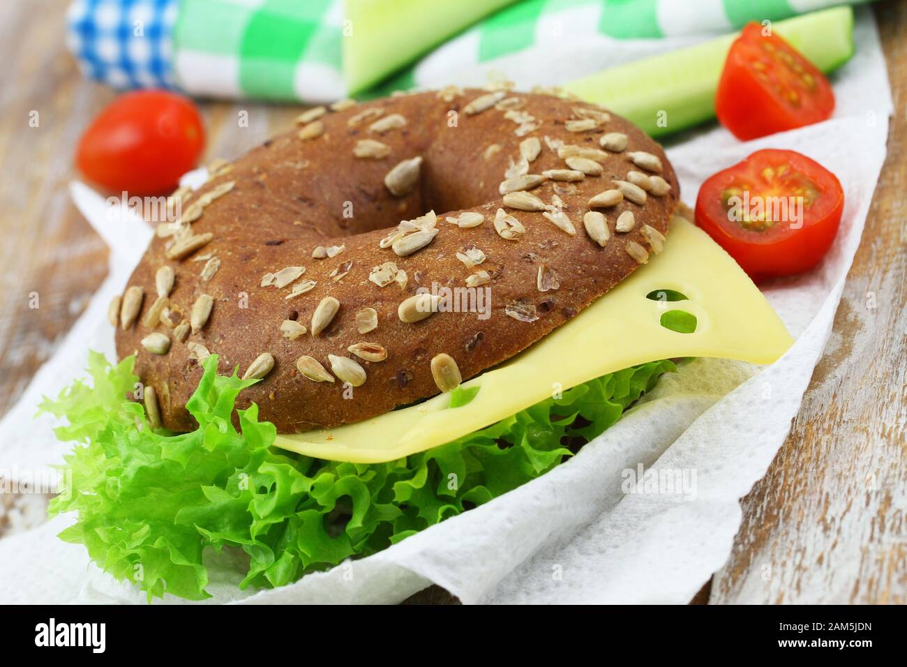 Nahaufnahme von braunem Bagel mit Schweizer Käse und Salat Stockfoto
