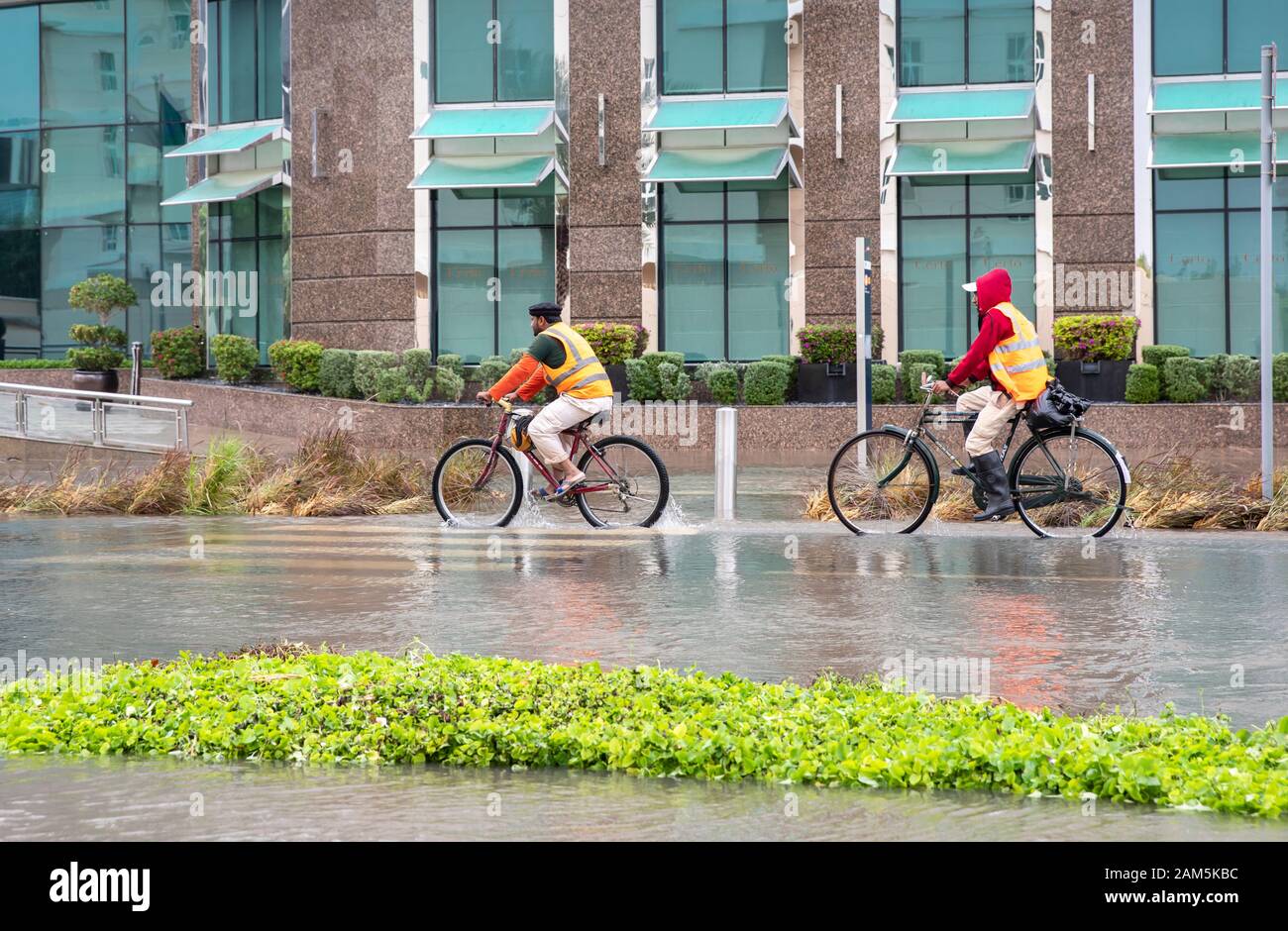 Dubai, Vereinigte Arabische Emirate, 11. Januar 2020: Menschen auf dem Fahrrad in die überfluteten Straßen von Dubai Stockfoto