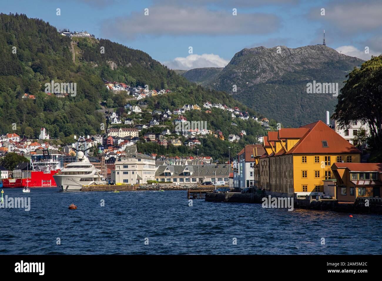 Die Einfahrt in den inneren Hafen von Bergen, Norwegen. Nordnes, Tollboden, Vaagen, Mount Floyen und Mount Ulriken. Stockfoto