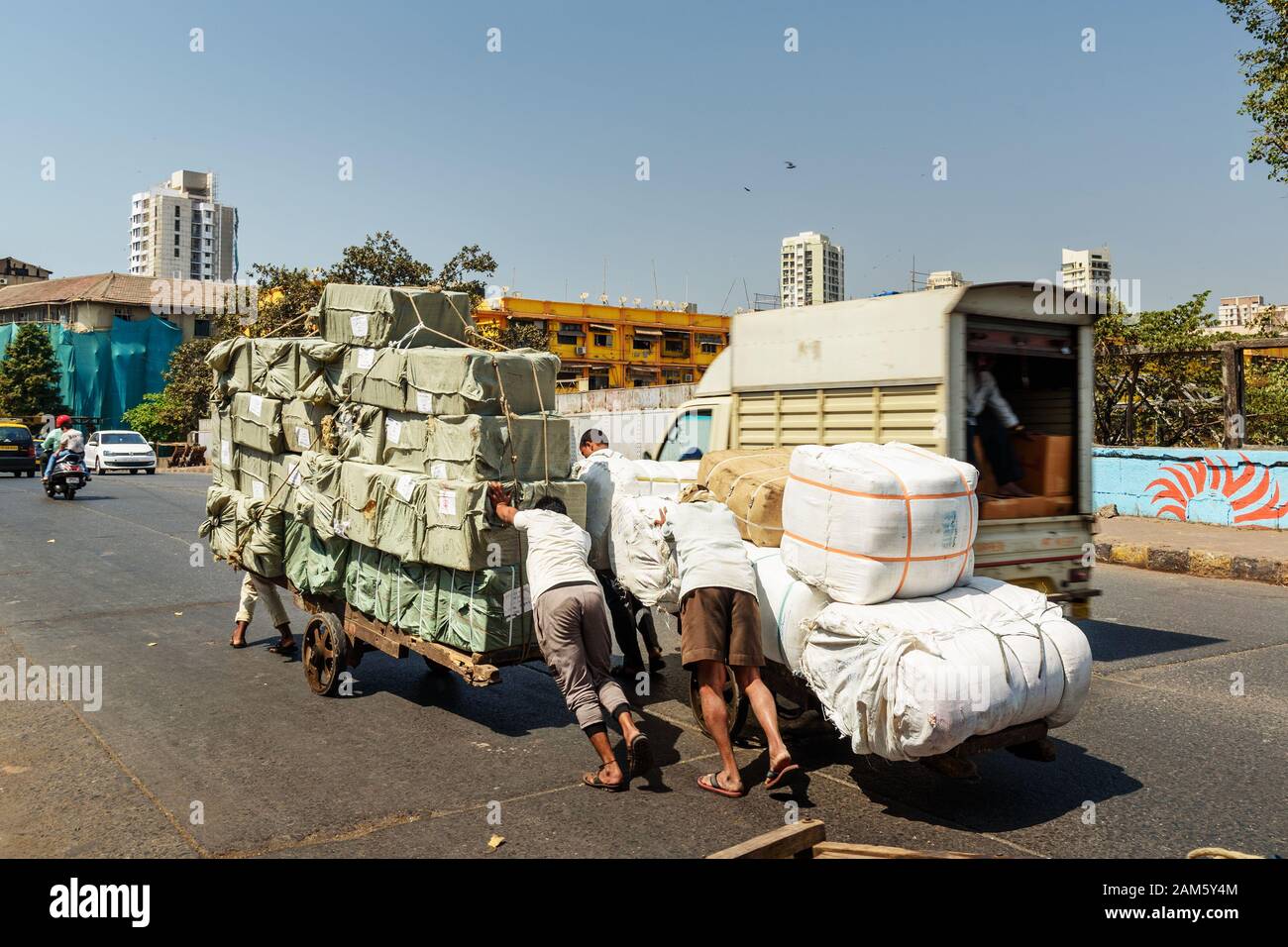 Männer drängten in Mumbai auf den Markt geladener Wagen. Indien Stockfoto