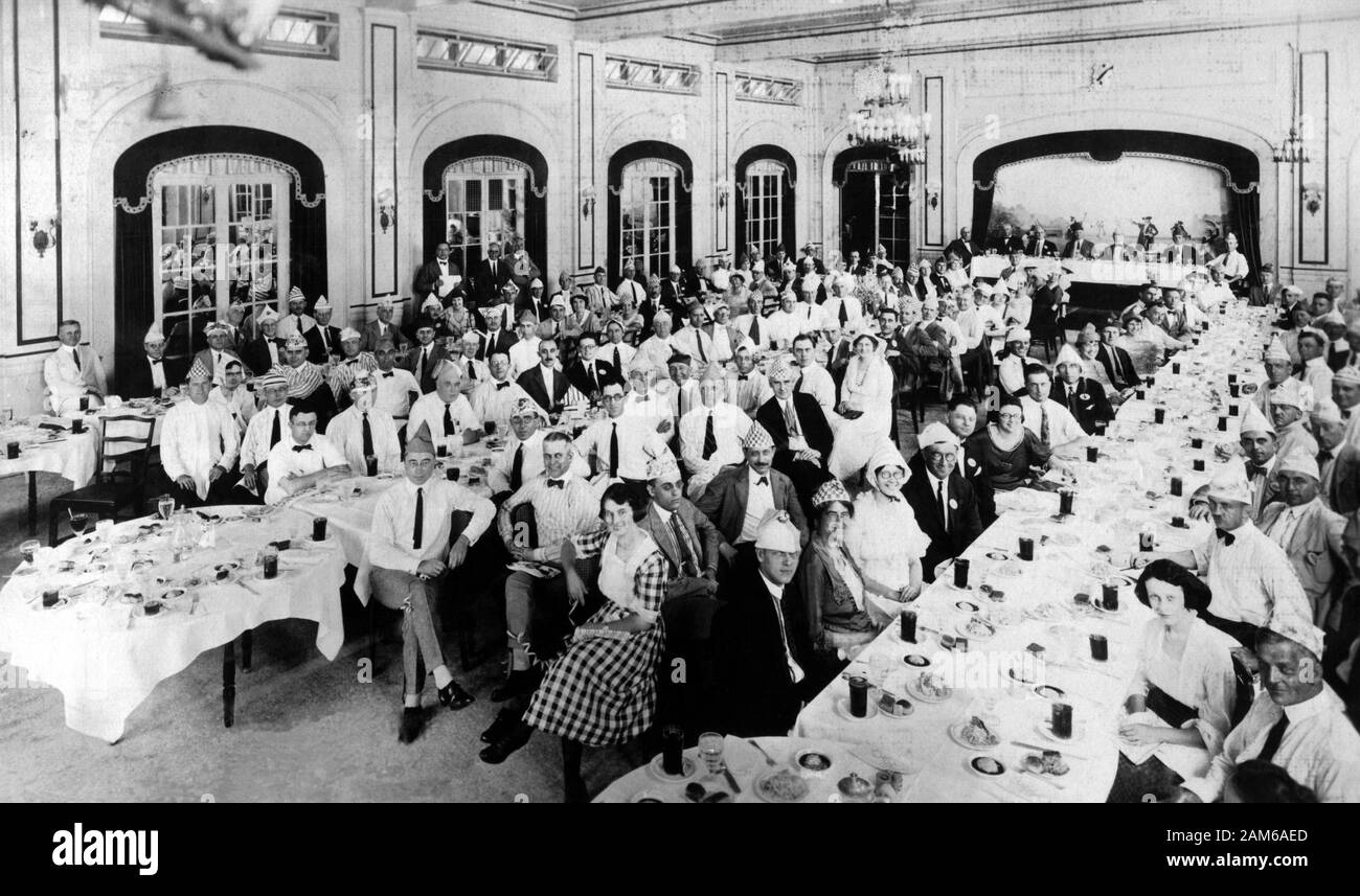 Große Gruppe von Geschäftsleuten und Frauen lustig Papier Hüte an einem Mittagessen treffen, 1921, USA, Nationale Schule für Sekretärinnen. Stockfoto