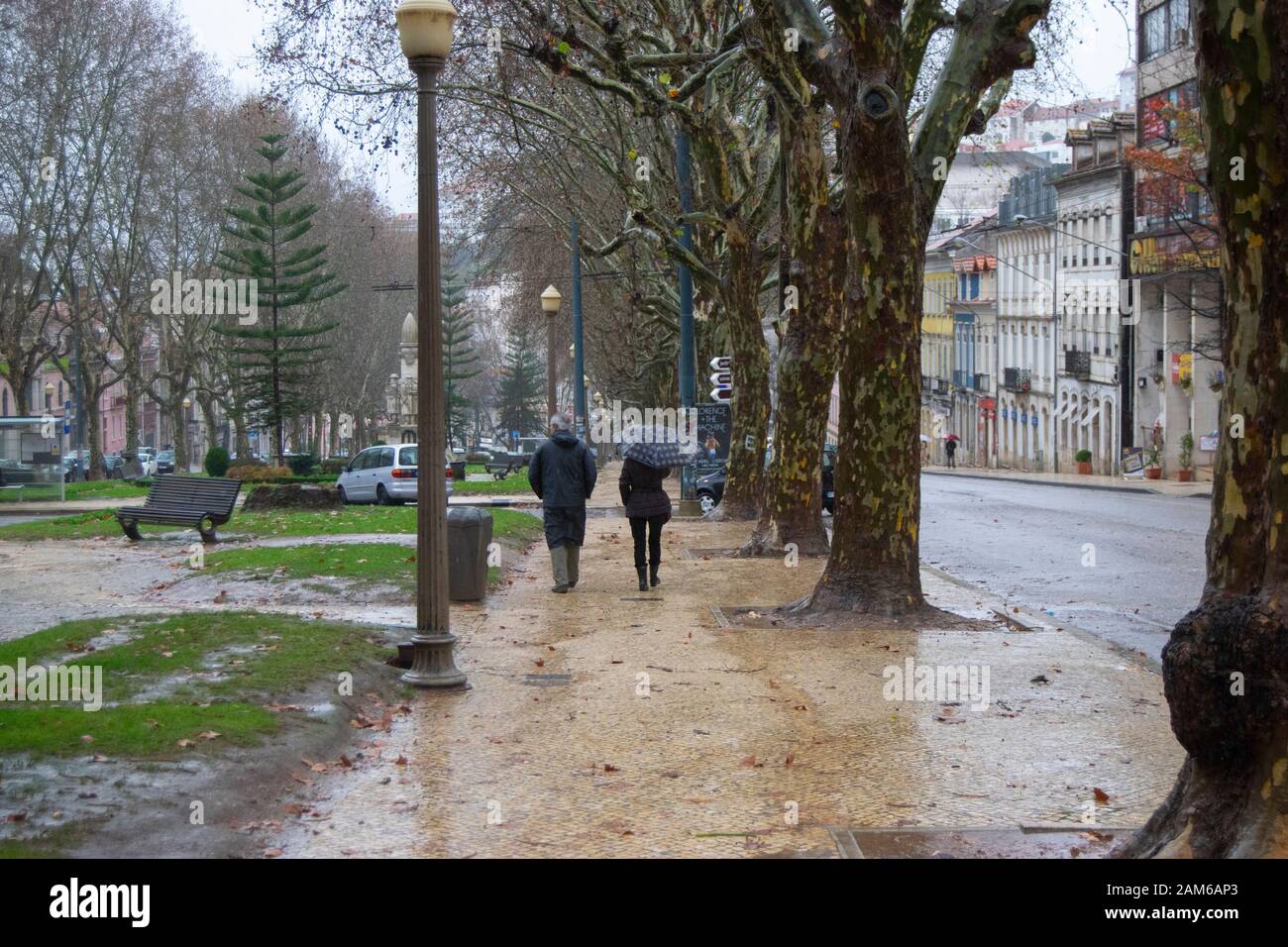 COIMBRA, PORTUGAL - 04. Januar 2016 - Menschen versuchen und halten sich bei starkem Regen in der Praca da Republica im Zentrum von Coimbra Portugal trocken Stockfoto