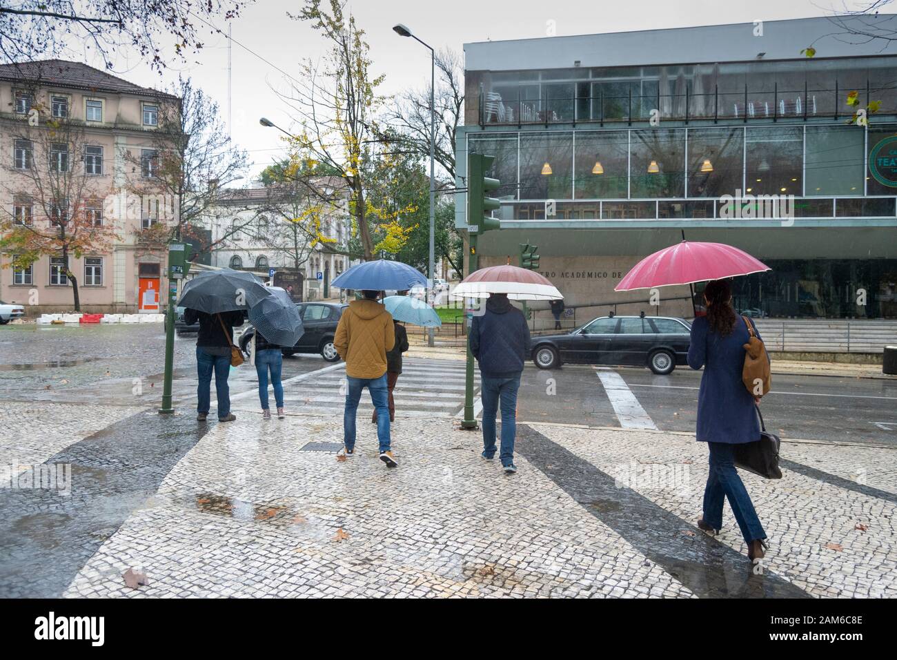 COIMBRA, PORTUGAL - 04. Januar 2016 - Menschen versuchen und halten sich bei starkem Regen in der Praca da Republica im Zentrum von Coimbra Portugal trocken Stockfoto
