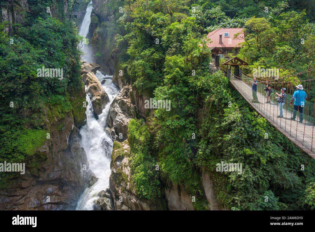 Wasserfall El Pailón del Diablo und Brücke mit Touristen am Fluss Pastaza bei Baños in Ecuador. Stockfoto