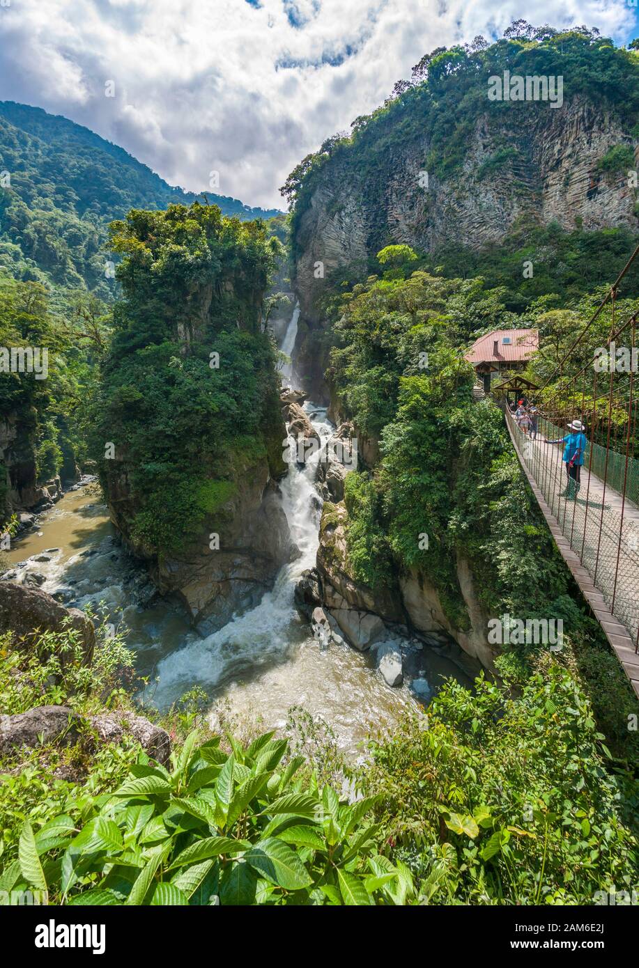 Wasserfall El Pailón del Diablo und Brücke mit Touristen am Fluss Pastaza bei Baños in Ecuador. Stockfoto