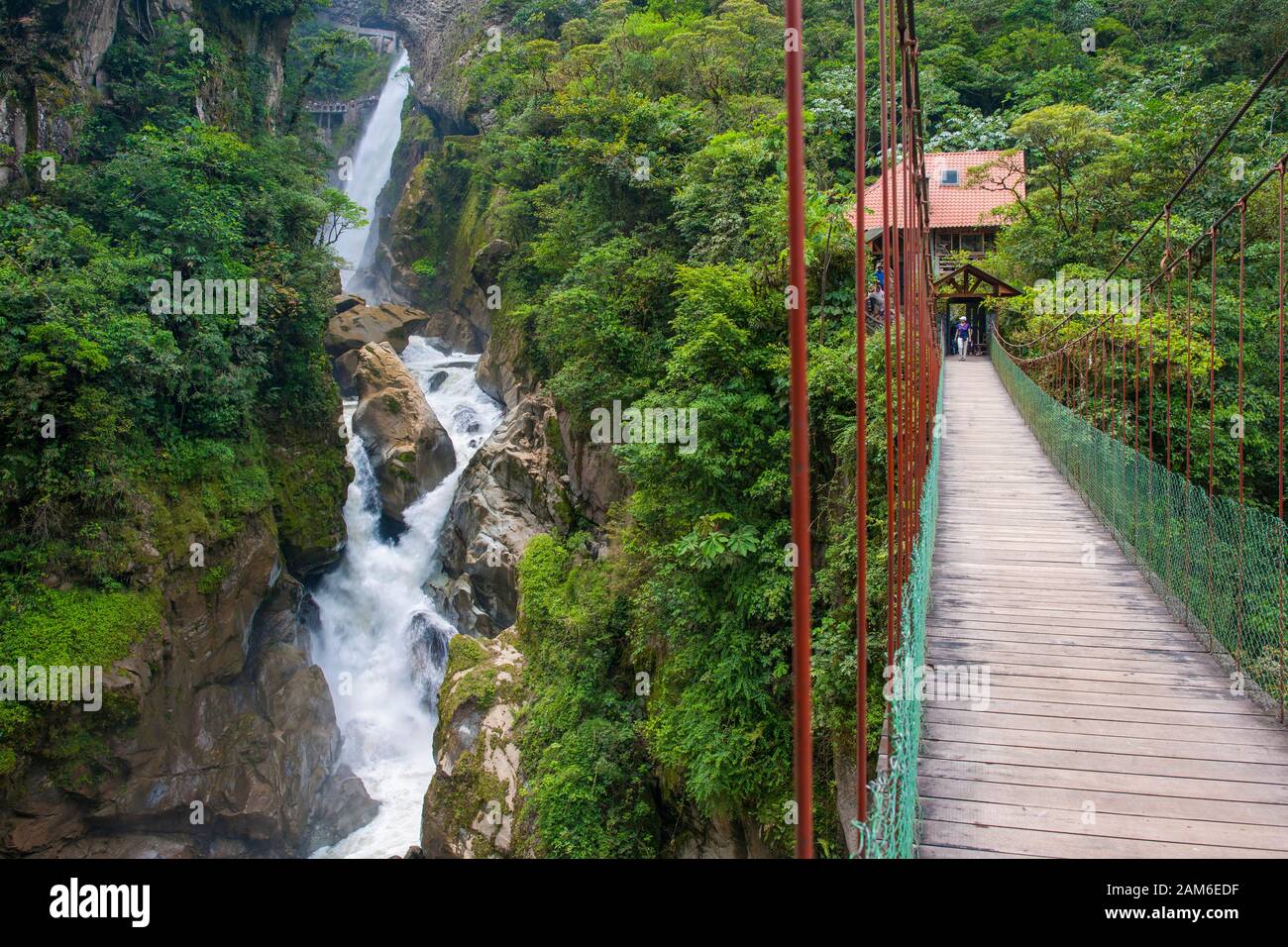 Wasserfall El Pailón del Diablo und Brücke mit Touristen am Fluss Pastaza bei Baños in Ecuador. Stockfoto