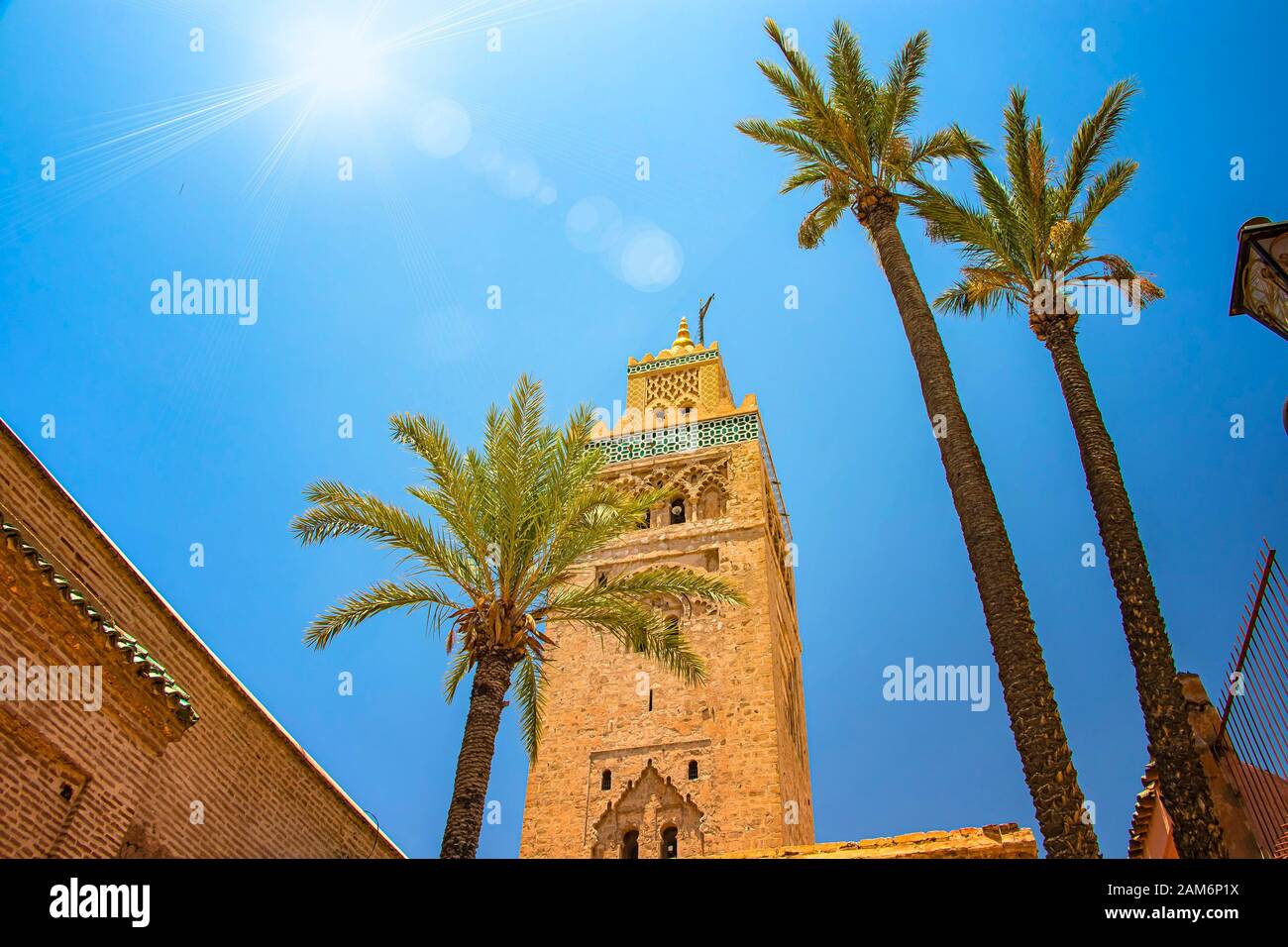 Turm des Minaretts der Koutoubia-Moschee im Medina Viertel von Marrakesch, Marokko. Es gibt wunderschöne grüne Palmen. Blauer Himmel ist im Hintergrund. Stockfoto