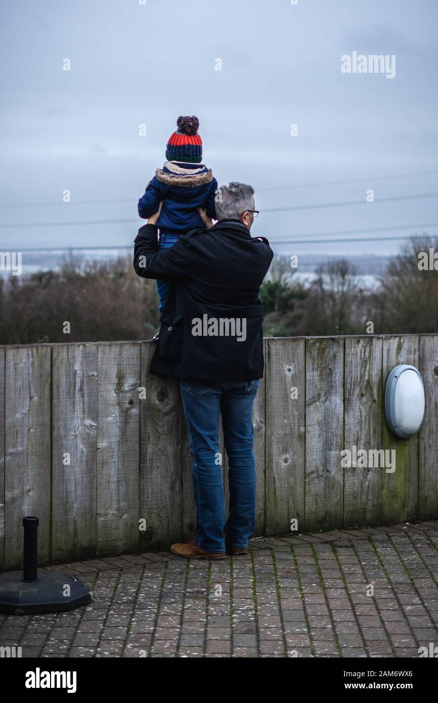 Ein Großvater, der seinen Enkel hoch hält, um einen Blick zu werfen Stockfoto
