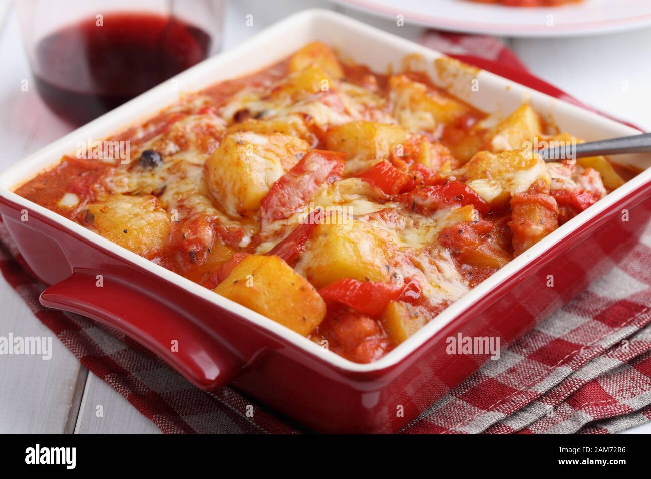 Vegetarische Ragout mit Kartoffeln, Paprika, Karotte und geriebenen Käse in einer Auflaufform auf einem rustikalen Tisch Stockfoto