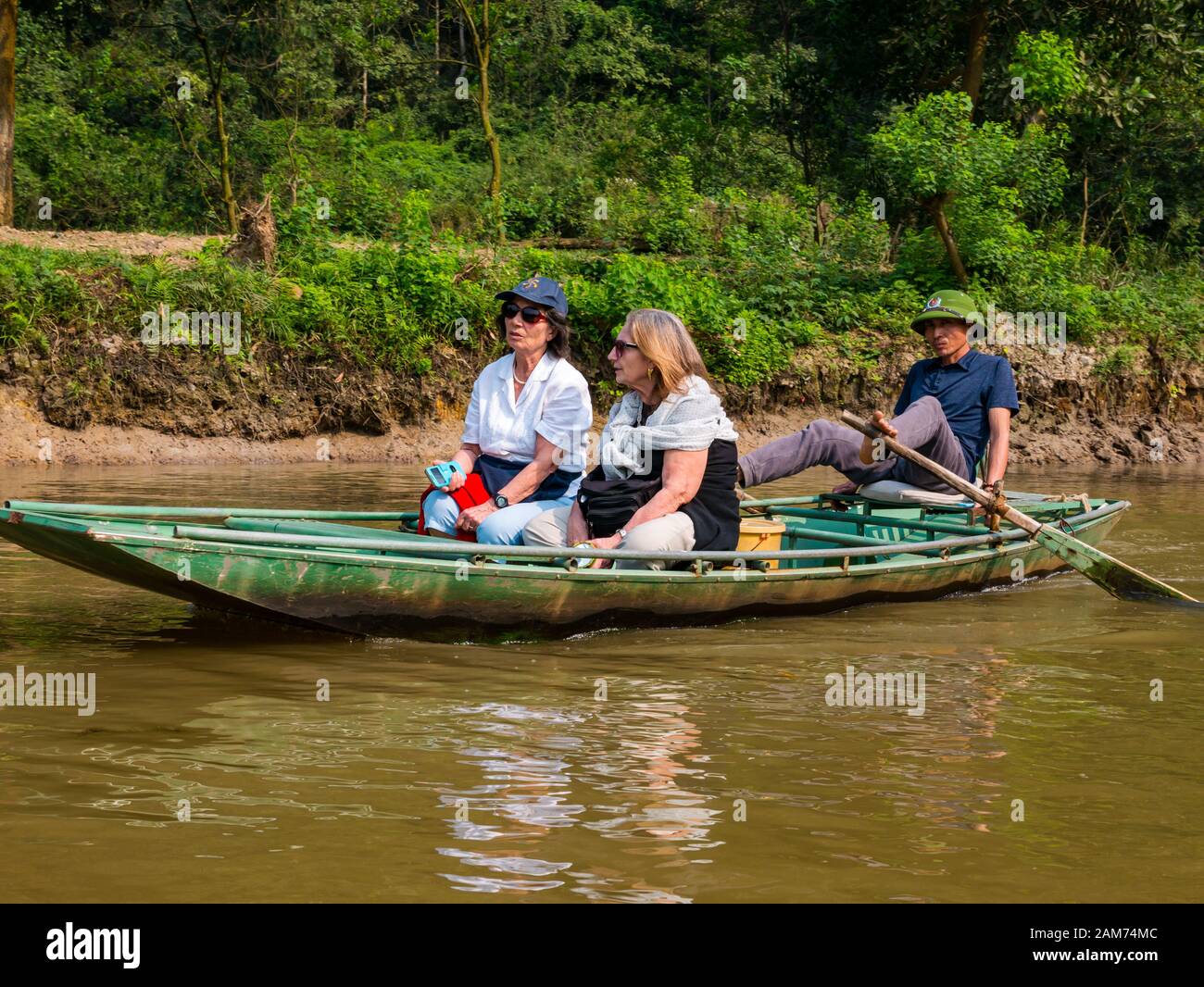 Touristen im Sampan ruderten mit Füßen, Tam Coc, Ninh Binh, Vietnam, Asien Stockfoto
