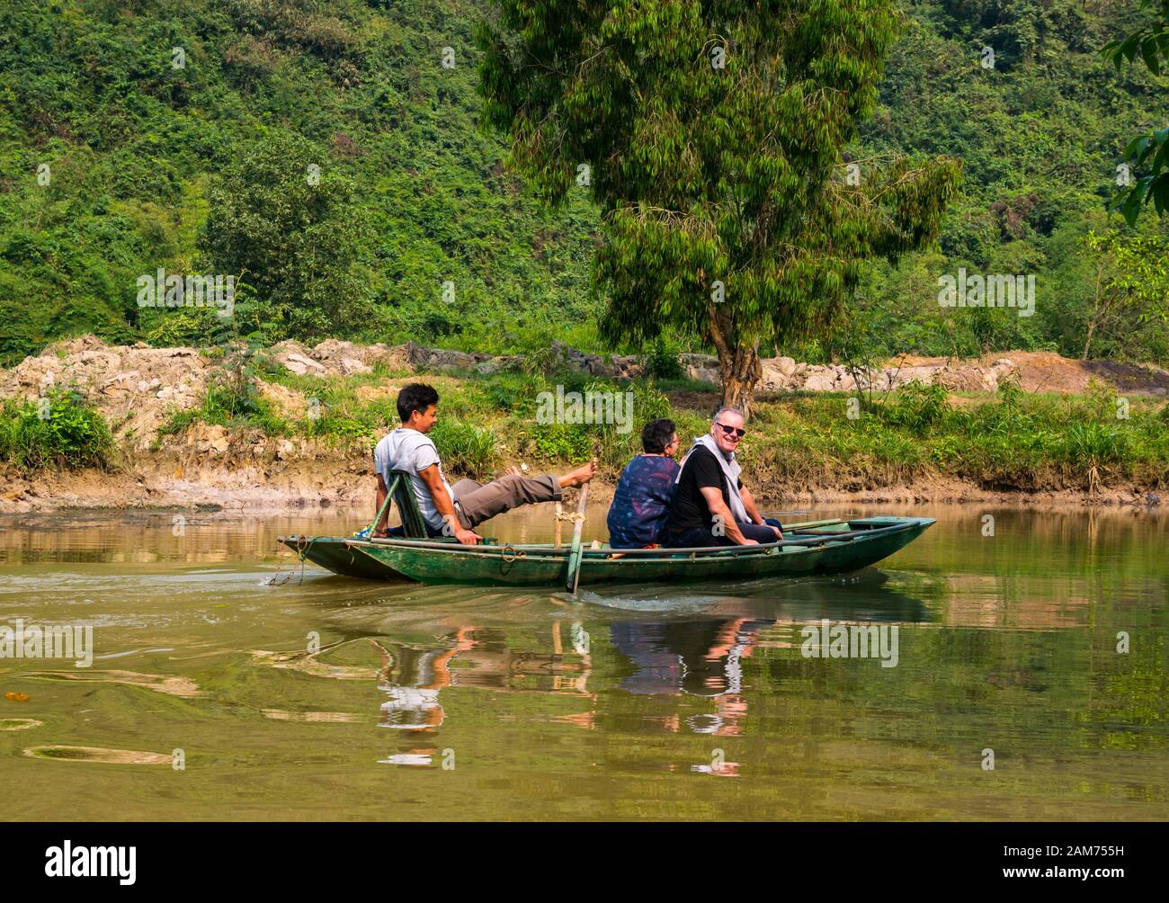 Touristen im Sampan ruderten mit Füßen, Tam Coc, Ninh Binh, Vietnam, Asien Stockfoto