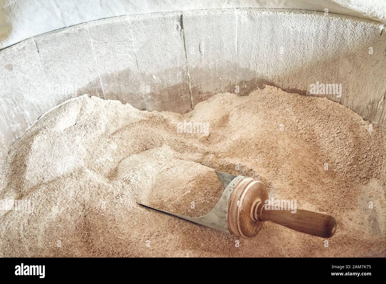 Frisch geerdetes Bio-Weizenbrot Mehl in einen Holzeimer mit einer Schaufel. Stockfoto