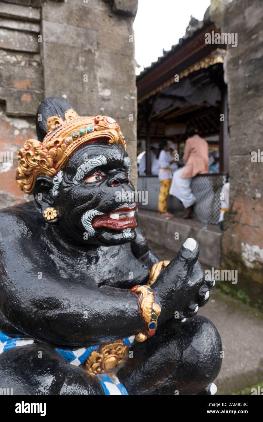 Schwarz bemalte Steinschnitzerei des Affen, der eine goldene Krone und Armbänder im Ulun Danu Temple Bedugul trägt Stockfoto