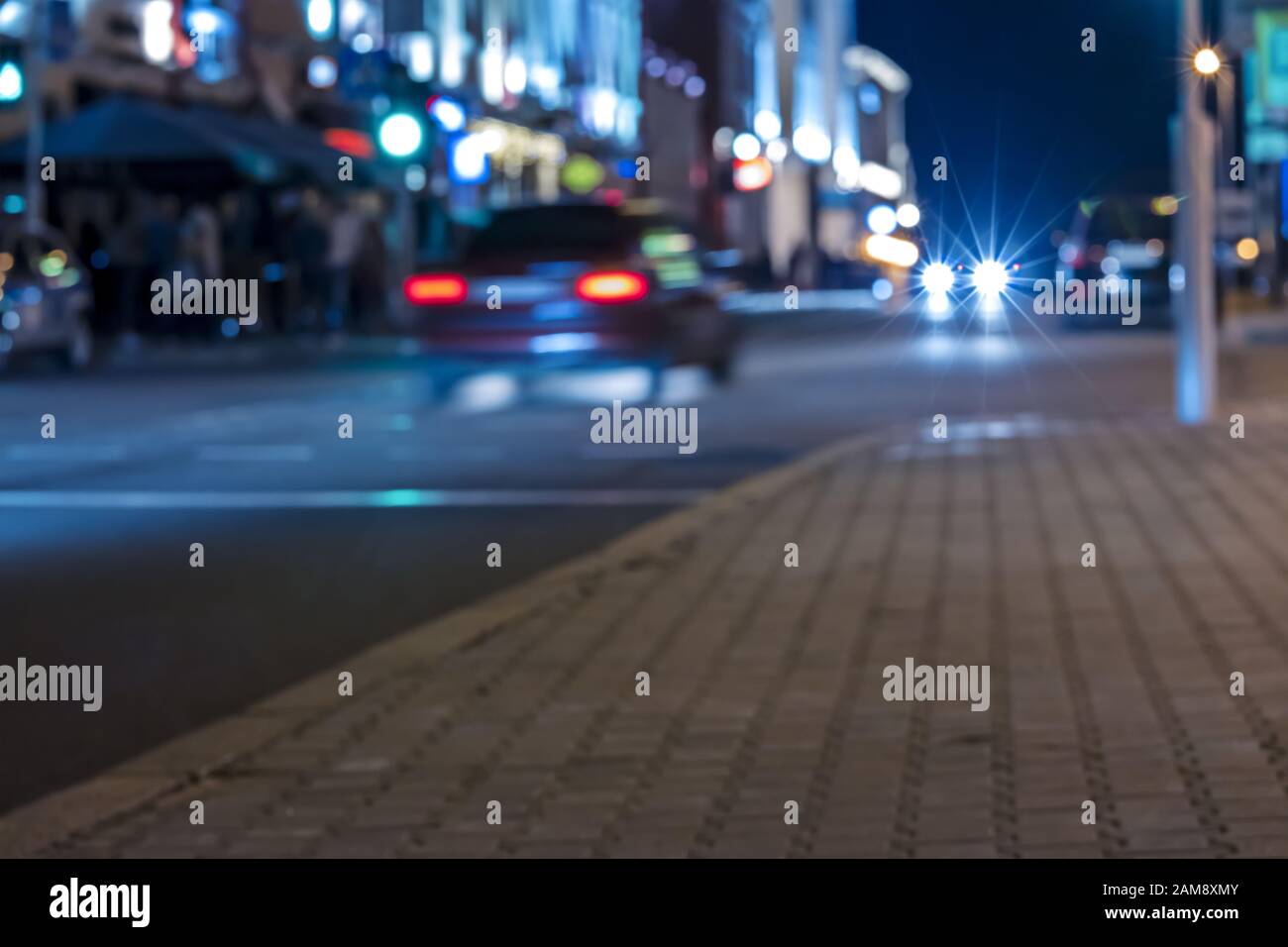 City Street in der Nacht. Verschwommener Blick auf Autos in Bewegung mit Licht Stockfoto