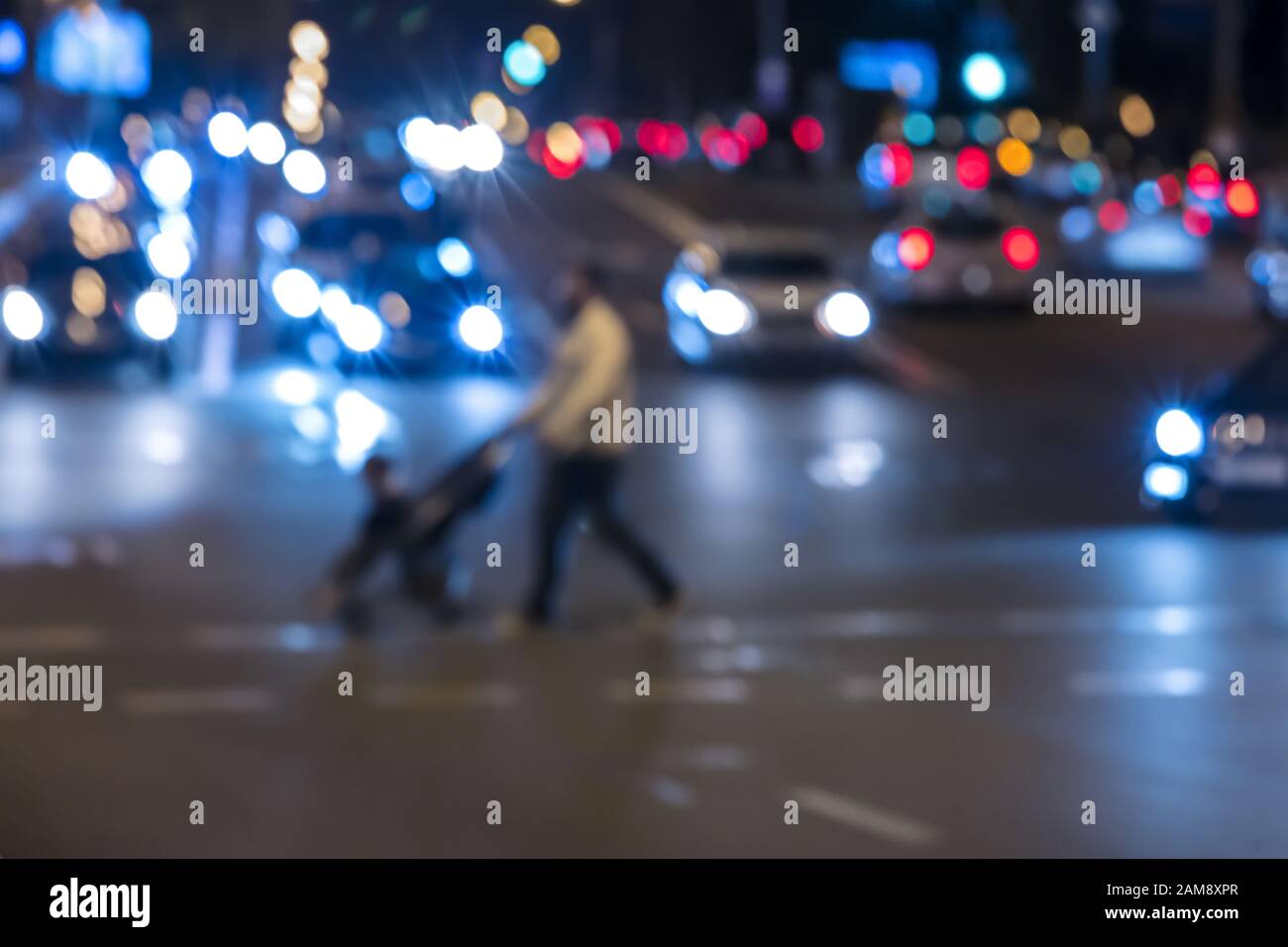 Verschwommener Blick auf die nächtliche Stadtstraße mit Autojau, Standlicht und Fußgänger Stockfoto