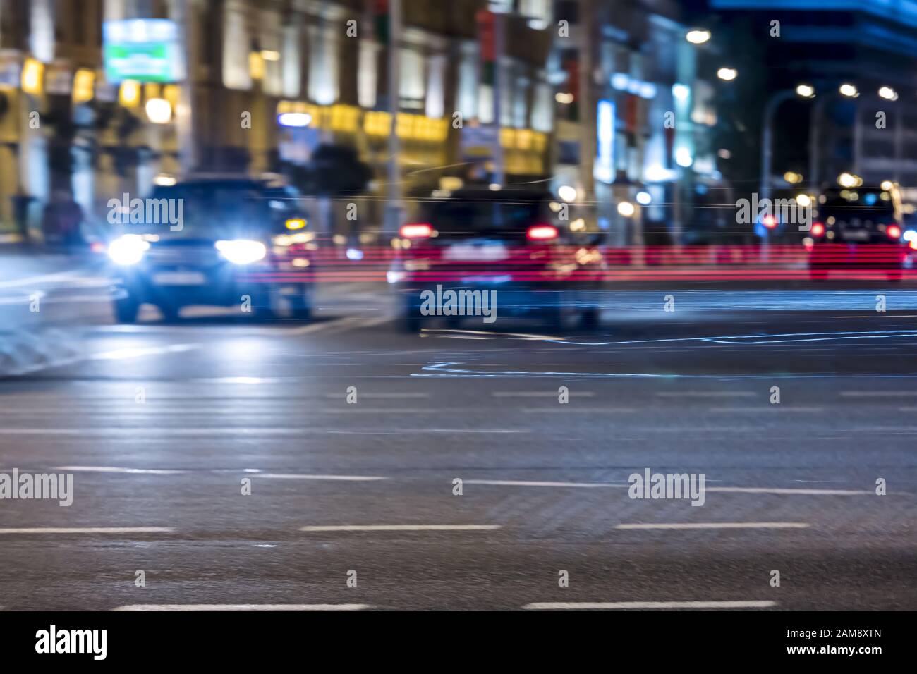 Farbenfrohe, verschwommene Autolampen, die die nächtliche Straße der Stadt beleuchten Stockfoto