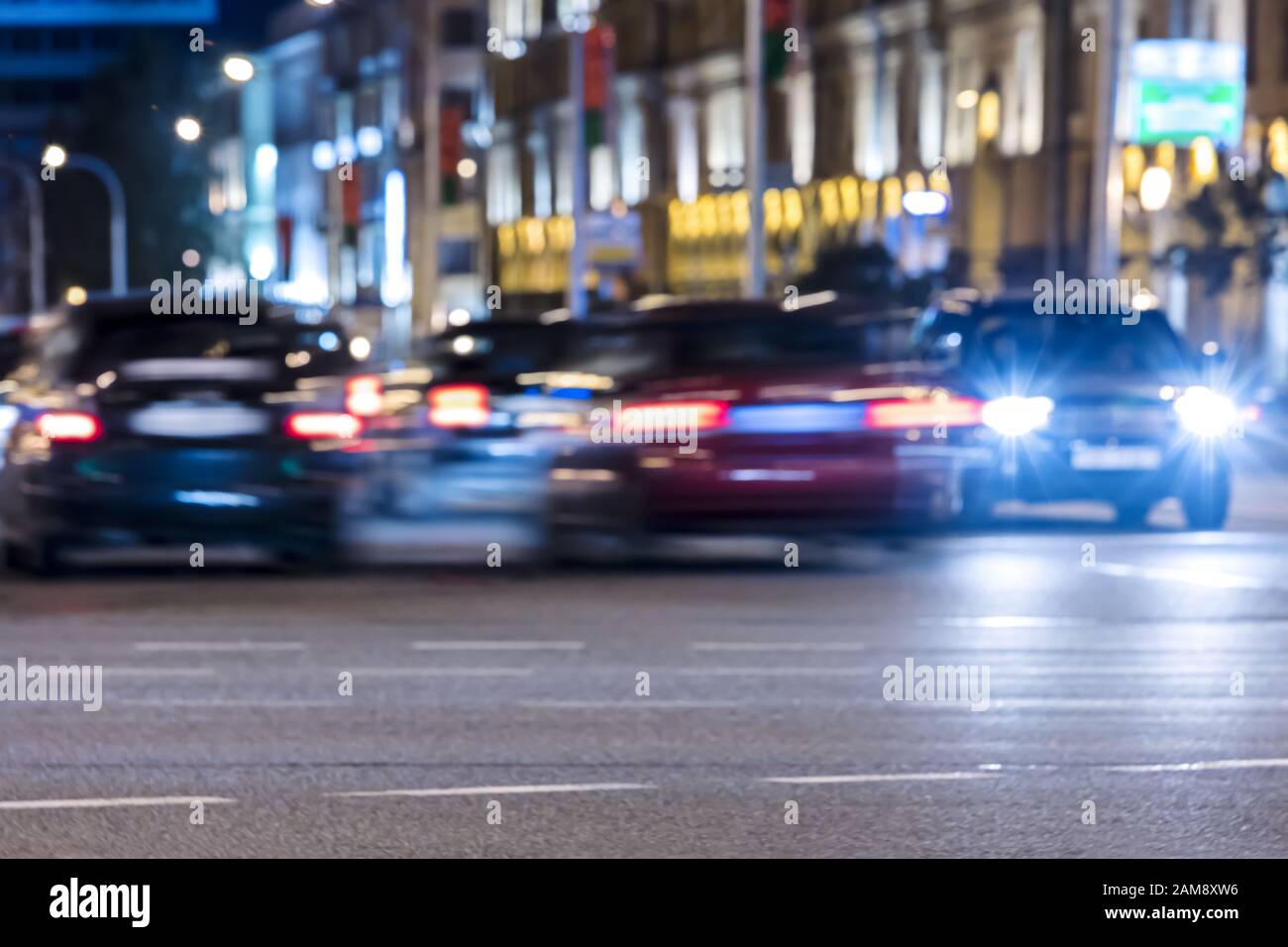 Autoverkehr mit bunten Lichtern, die dunkle Straßen beleuchten. Verschwommene Sicht Stockfoto