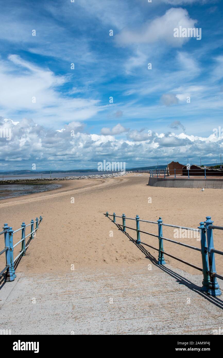 Sandiger Pfad hinunter zum Morecombe Strand mit blauen Geländern Stockfoto