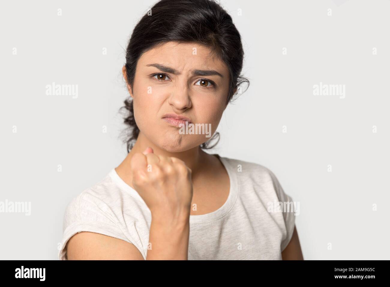 Aggressive wütende indische junge Frau klammert die Faust. Stockfoto