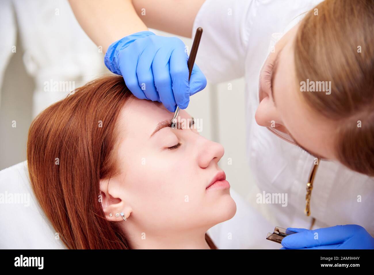 Junge Frau auf Augenbrauenkorrektur in der Klinik für Kosmetologie. Stockfoto