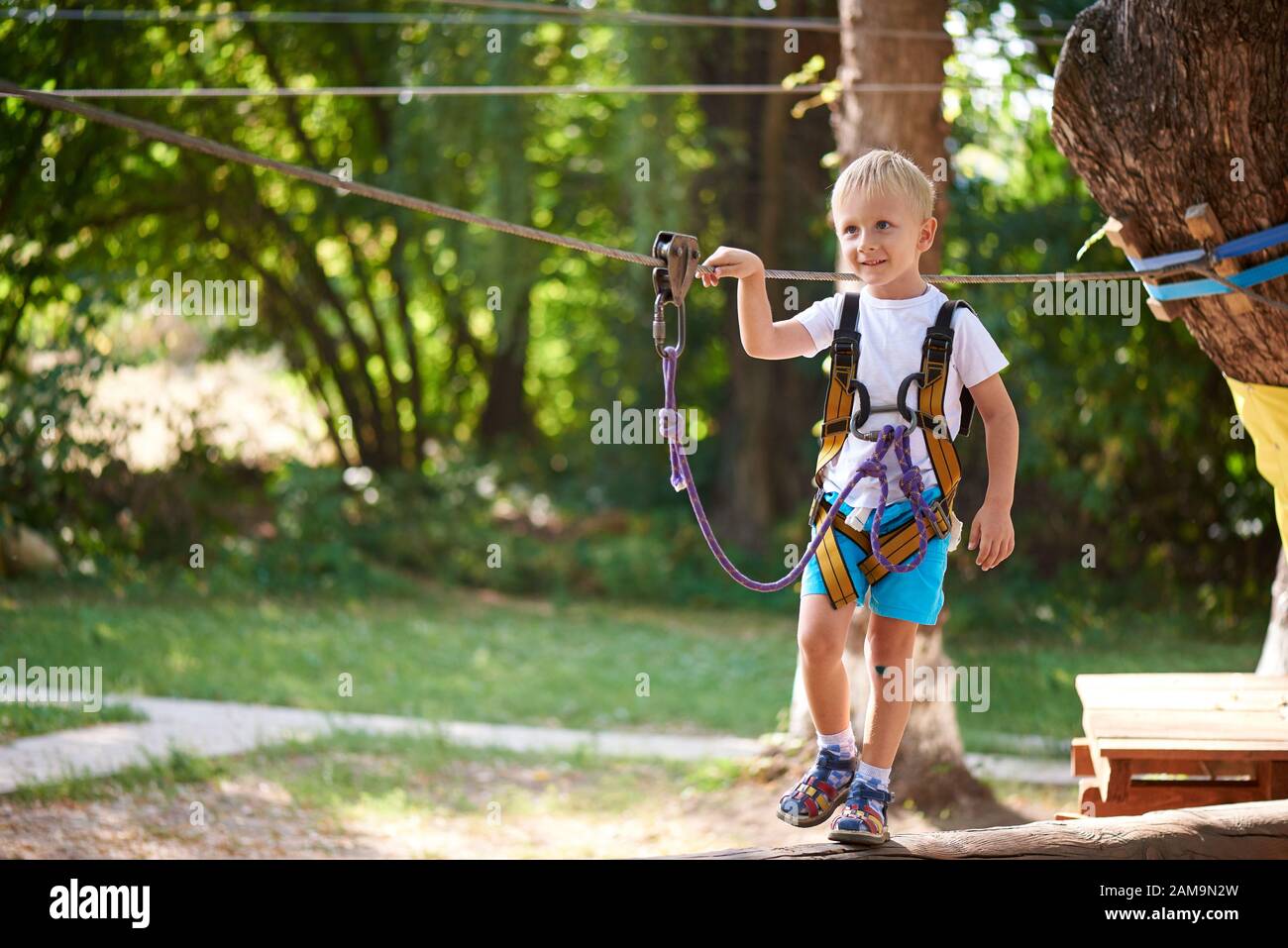 Der kleine Junge überwindet das Hindernis im Seilpark. Stockfoto