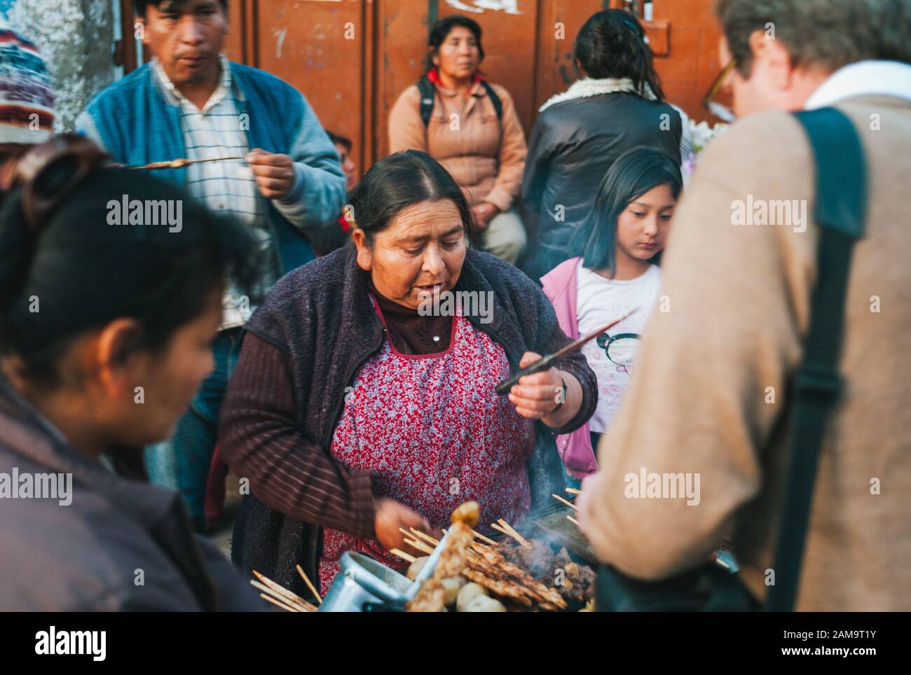 Urubamba, Cuzco Region, Peru - 29. Juli 2010: Frau grillt Anticucho Spieße Streetfood auf einer Belebten Market Street in Urubamba. Stockfoto