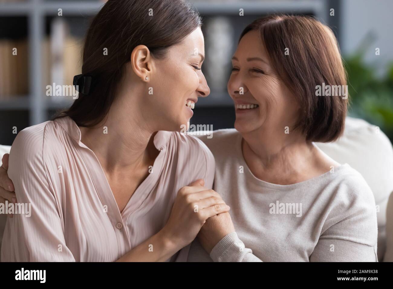 Glückliche Erwachsene Mutter und Tochter teilen Geheimnisse zu Hause Stockfoto