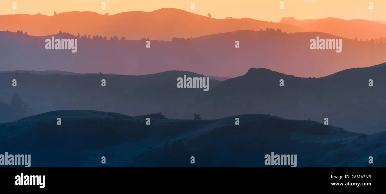 Blick auf die Hügel und Täler bei Sonnenuntergang, jede Schicht anders gefärbt; Santa Cruz Mountains; San Francisco Bay Area, Kalifornien Stockfoto