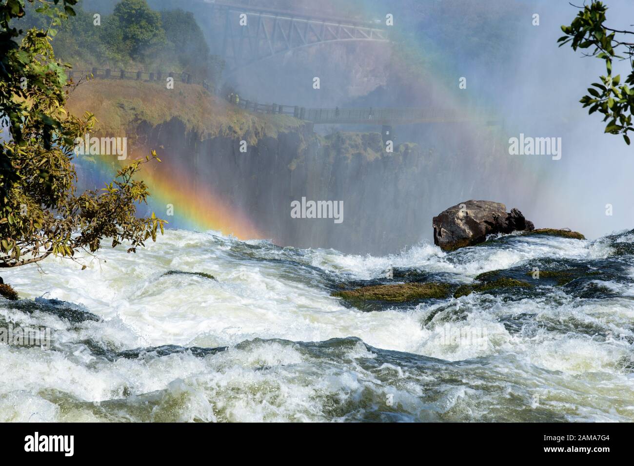 Aussicht, mit Regenbogen, über den Victoria Falls, mit Knife Edge Bridge und Victoria Falls Bridge im Hintergrund Stockfoto