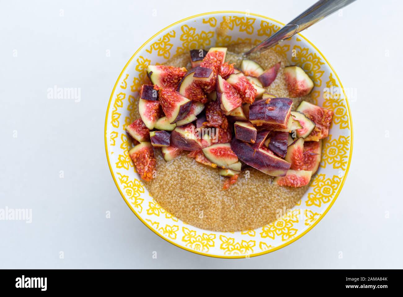 Amaranth Porridge zum Frühstück mit Feigen in einem gelben Schüssel, Ansicht von oben Stockfoto