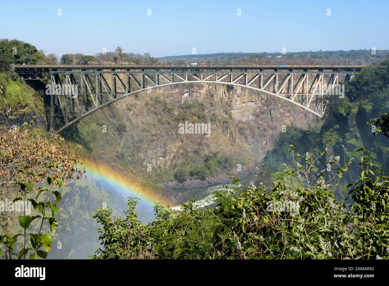 Die Victoria Falls Brücke über den Sambesi Fluss zwischen Simbabwe und Sambia, mit Regenbogen Stockfoto