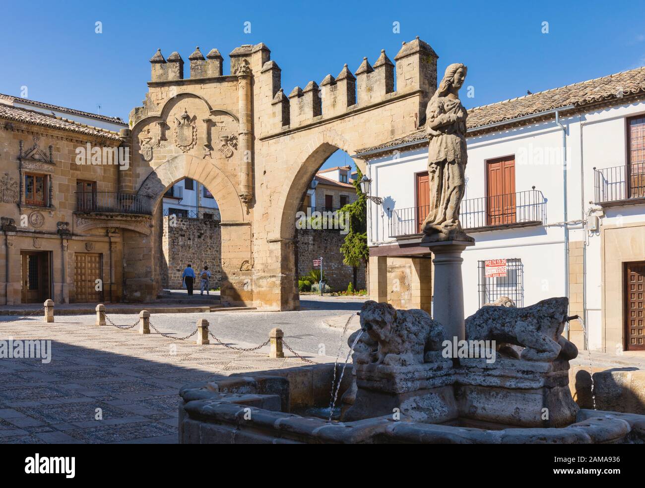 Fuente de los Leones, oder Brunnen des Löwen, in der Plaza del Populo, Baeza, Provinz Jaen, Andalusien, Spanien. Die ornamentale City Gate in der Rückseite Stockfoto