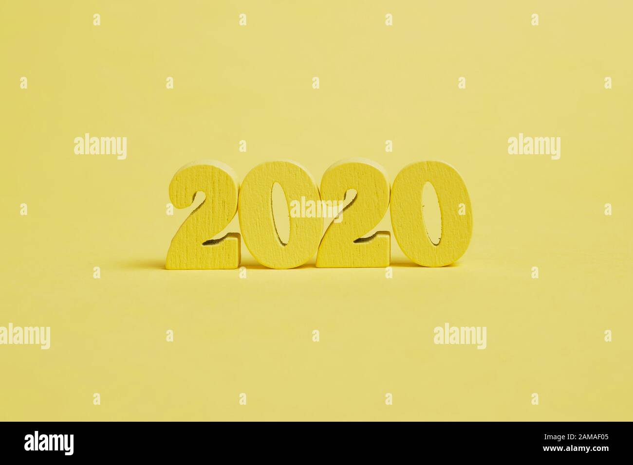 Holzfiguren 2020 auf gelbem Grund. Nahaufnahme. Stockfoto