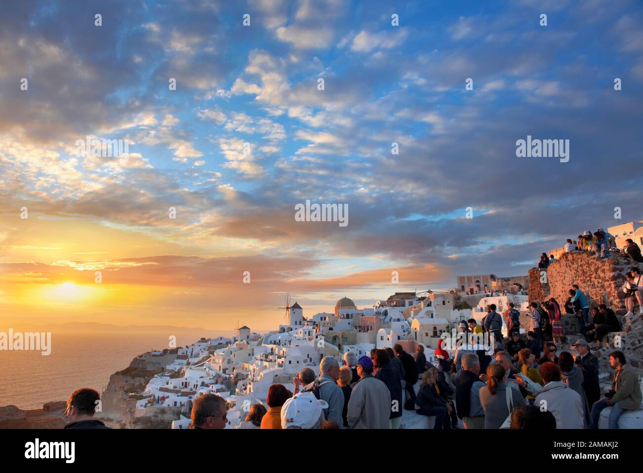 Oia (Ia) Santorini Windmühlen und Stadt bei Sonnenuntergang, Thira Island, griechische Kykladen-Inseln Stockfoto