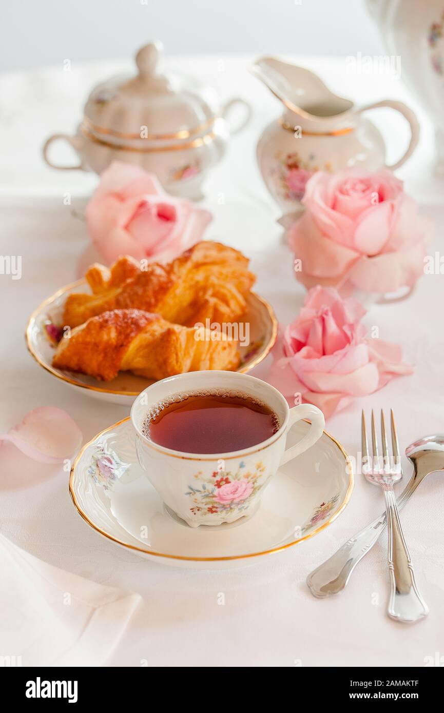 Frühstück mit Tee, Croissants und frischen Erdbeeren, serviert mit feinen porzellan-porzellan-Set mit Rosen Stockfoto