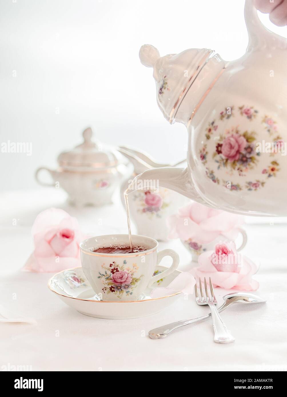 Ein Set aus feinem Porzellanteeset mit Blumenrosenmuster und Teetopf, Zuckertopf, Topf und Teetasse. Stockfoto