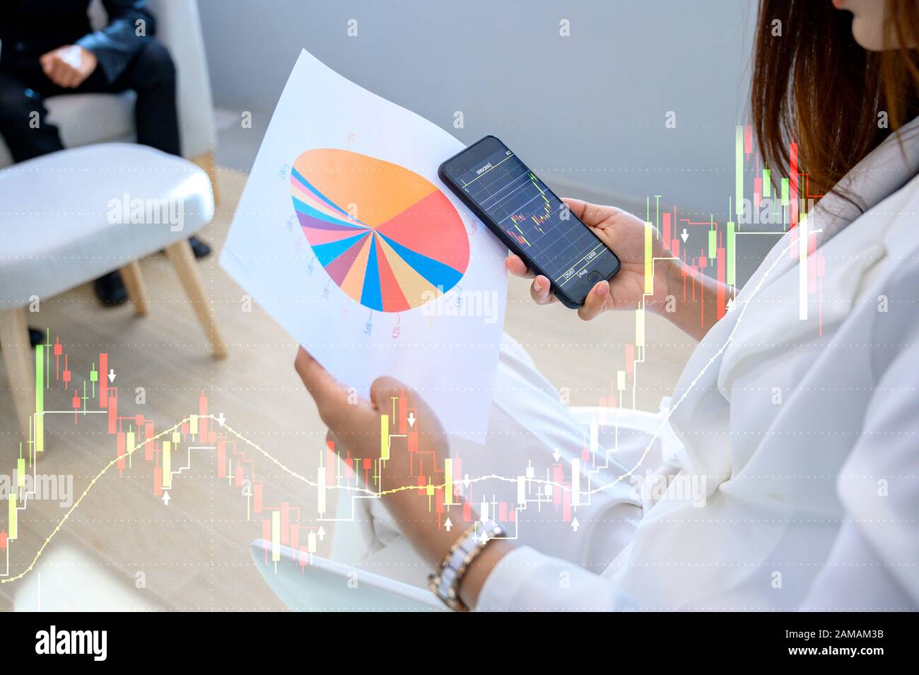Geschäftsfrauen, die weiße Anzüge tragen, spielen gerne Mobiltelefone, sehen Sie sich die wichtigsten Wachstumsdiagramme des Unternehmens an Stockfoto