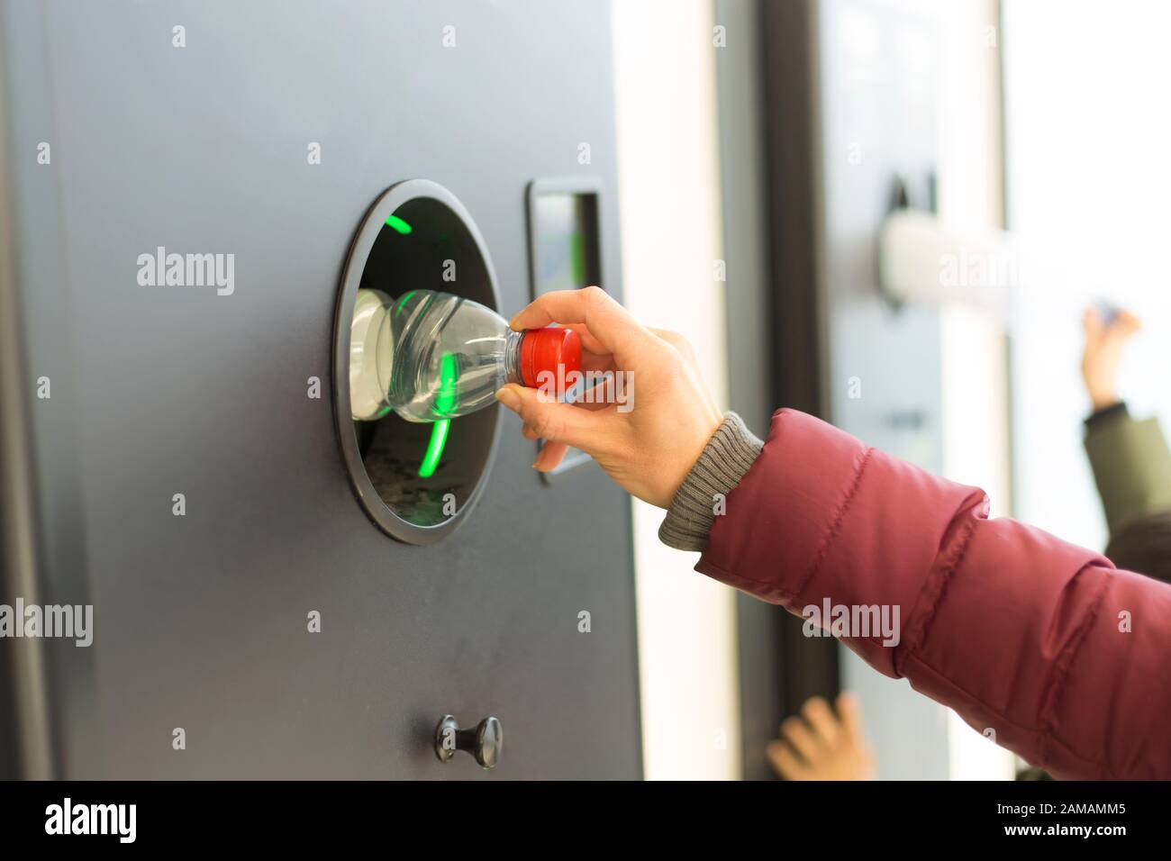 Eine Kunststoffflasche wird in einem Abfallbehälter entsorgt. In einem Abfallbehälter sortieren. Umweltverschmutzung. Stockfoto