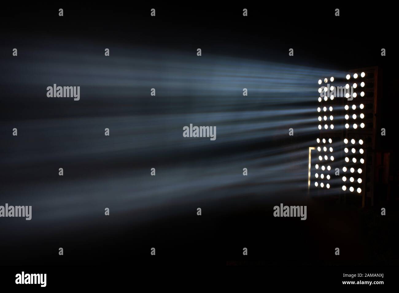 Einige Strahler beleuchten den dunklen Bereich nachts mit Lichtstrahlen Stockfoto