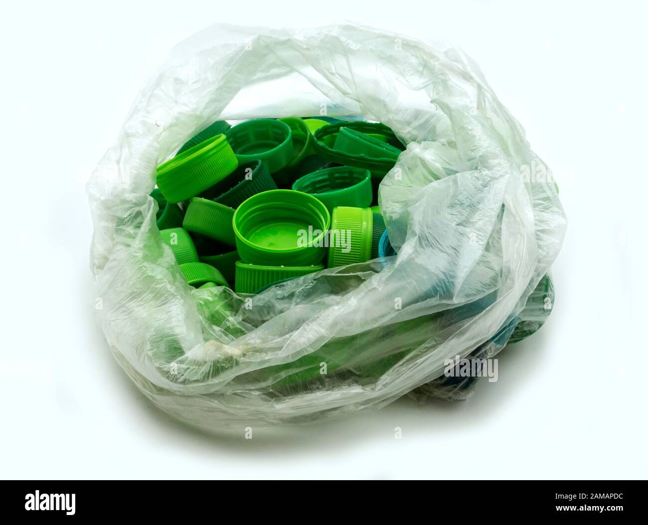 Grüne Kunststoff-Flaschenverschlüsse nach Farben sortiert in transparenten Einmal-Plastiktüten. PP eine PET-Verschmutzung. Recycling-Lösungen für Kunststoffabfälle. Stockfoto