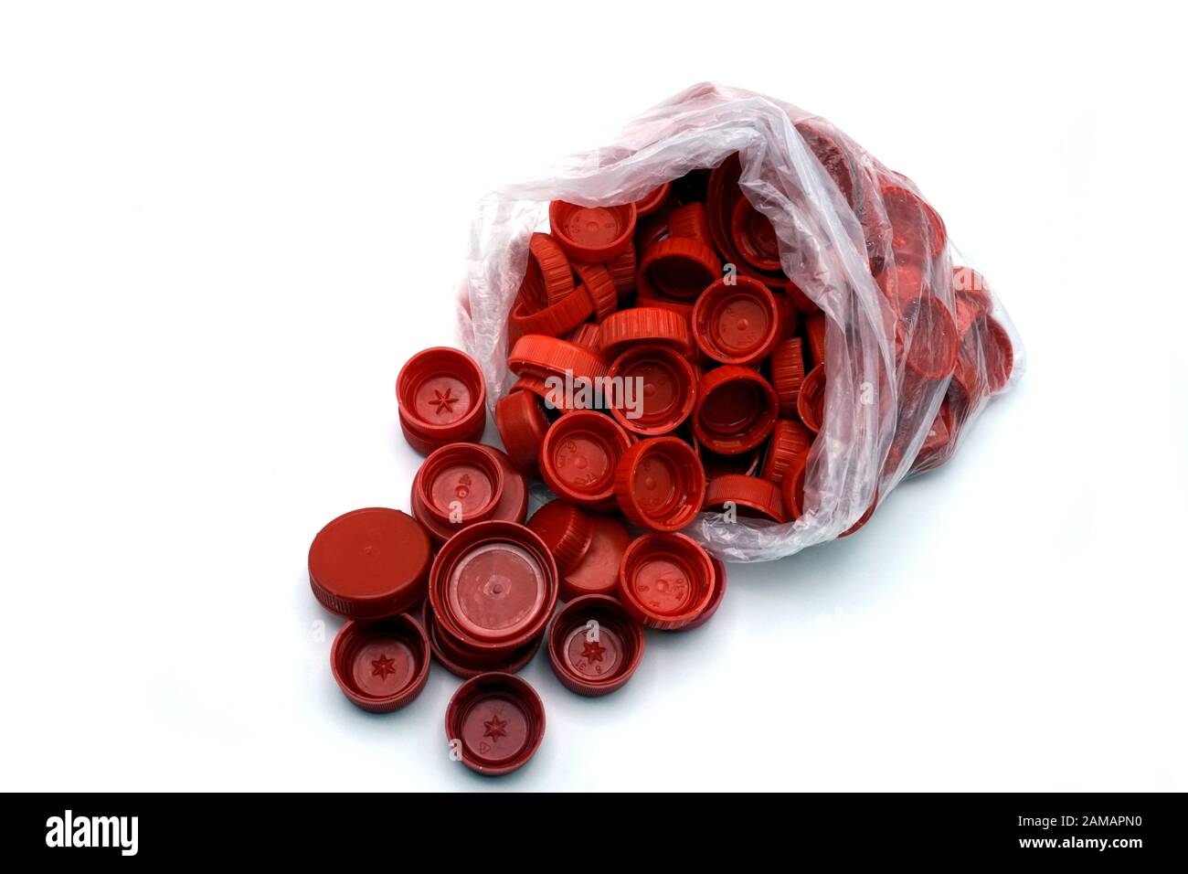 Rote Kunststoff-Flaschenverschlüsse, sortiert nach Farben in transparenten Einmalbeuteln aus Kunststoff. PP eine PET-Verschmutzung. Recycling-Lösungen für Kunststoffabfälle. Stockfoto