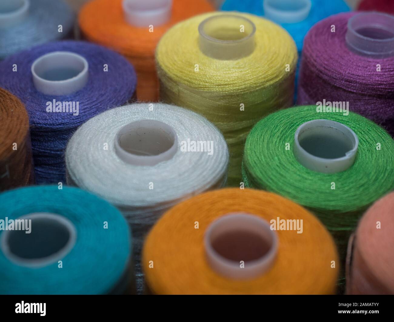 Viel Nähen von farbigem Faden. Gewinderollen. Bunte Fäden im Karton. Struktur des Nähzubehörs Stockfoto