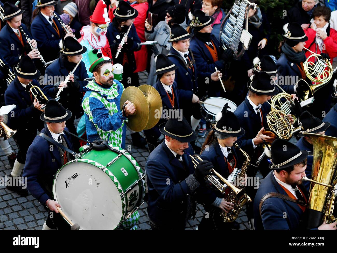 Murnau, Deutschland. Januar 2020. Ein Mann in Clownkostüm spielt mit der Musikkapelle am Schäfflertanz im Murnauer Obermarkt. 16 ausgewählte Männer tanzen alle sieben Jahre den cooper-tanz. Die Tradition des Zunfttanzes der Murnauer Kojer - auch Schäffler genannt - soll bis ins Jahr 1859 zurückreichen. Credit: Angelika Warmuth / dpa / Alamy Live News Stockfoto