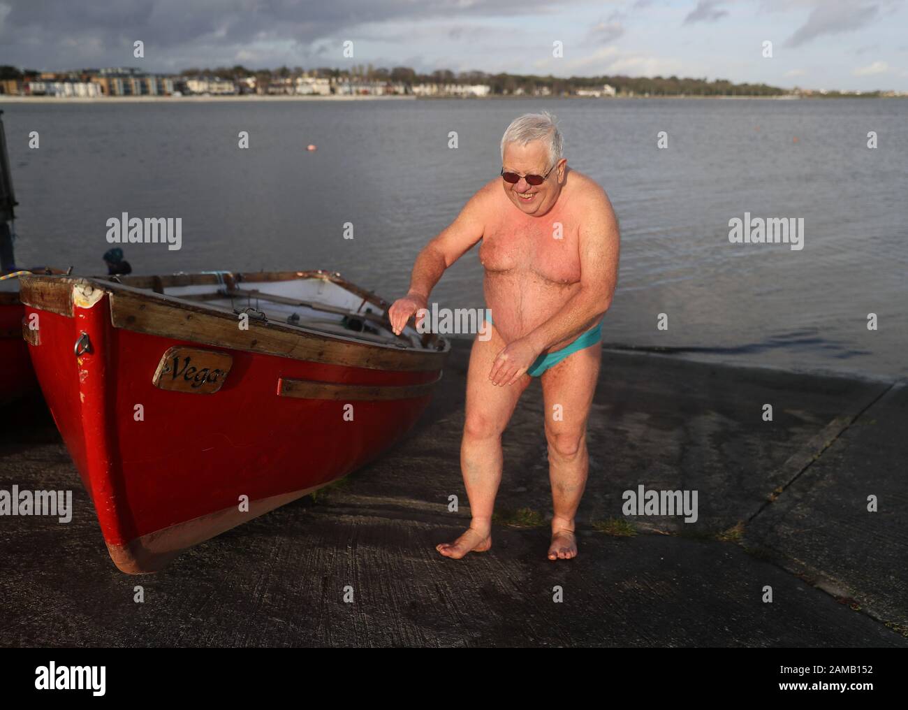 Ein Schwimmer macht sich an einem schönen Tag auf der Bull Island in Dublin auf den Weg nach oben, da Met Eireann zwei Statusorange Windwarnungen vor der Ankunft von Storm Brendan morgen herausgegeben hat. Stockfoto